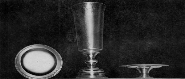 COMMUNION SERVICE IN USE AT SMITH'S HUNDRED, 1618.

This three piece communion service now at St. John's Church, Elizabeth City Parish, Hampton, Virginia,
has the longest history of use in the United States of any church silver. The set, a gift to the church founded
in 1618 at Smith's Hundred in Charles City County, was made possible by a legacy in the will (date 1617) of
Mrs. Mary Robinson of London. Smith's Hundred renamed Southampton Hundred, 1620, was practically
wiped out in the Indian Massacre of 1622. This communion set delivered in 1627 to the Court at Jamestown
for safe keeping, supposedly, then was given to the second Elizabeth City Church built on Southampton (now
Hampton) River. The inscription in one line on the base of the Chalice is: The Communion Cupp for Snt
Marys Church in Smiths Hundred in Virginia. Hall marks on all three pieces bear London date-letters for
1618-19.

Courtesy Mrs. L. T. Jester and Mrs. P. W. Hiden